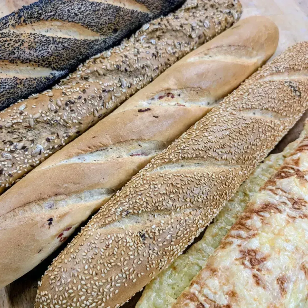 Baguettes mit Mohn, Sesam, Körnern und Käse nebeneinander