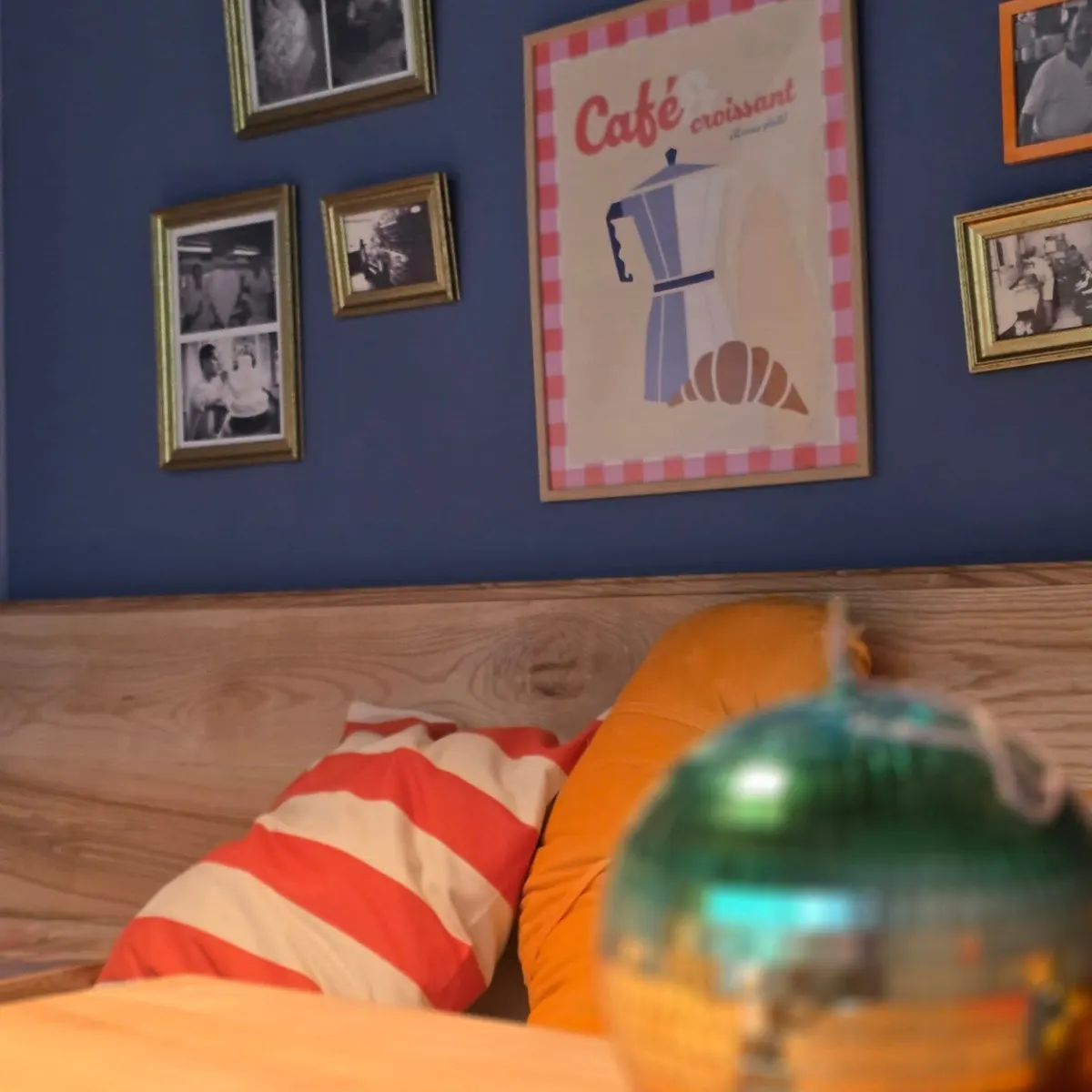 Sitzecke im Café mit blauer Wand, gerahmten Bildern und Kissen