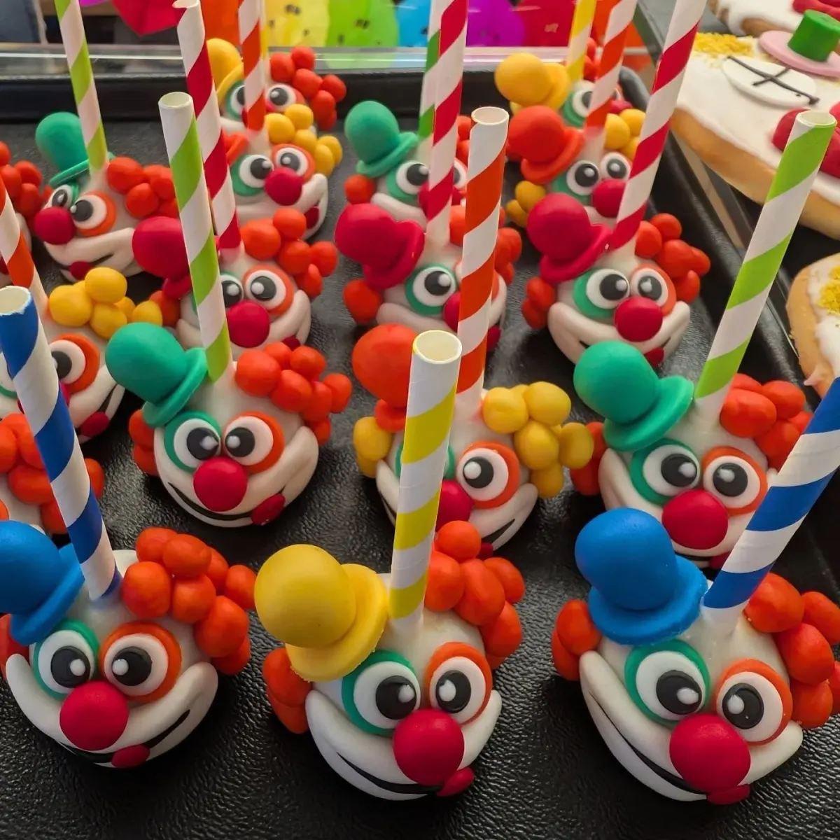 Cake-Pops als Clownsgesichter mit bunten Marzipanhüten