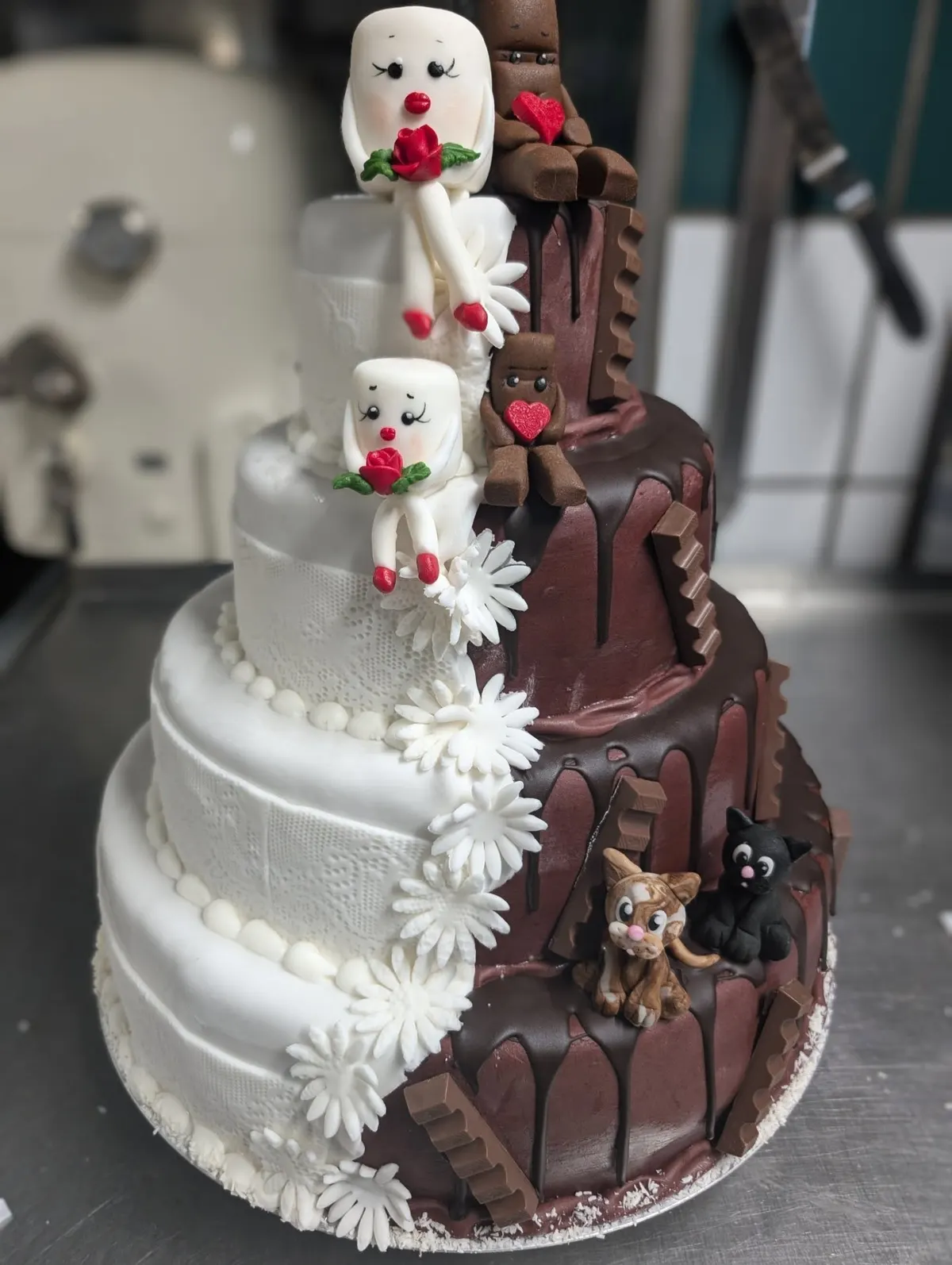 Zweifarbige Motivtorte, halb weiß halb Schokolade, mit Marzipanfiguren