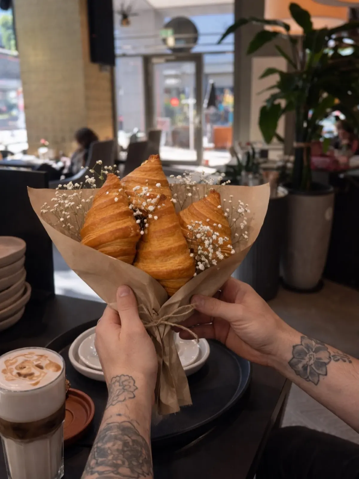 Drei Croissants in Papier gewickelt und mit Schleierkraut zu einem Strauß gebunden